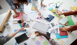 Adults gathered around table working on design